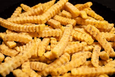 Dilimlenmiş baharatlı dondurulmuş patates kızartması..