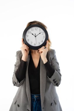 Bir kadın gözünün önünde bir saat tutuyor. Beyazda izole edilmiş. Son teslim tarihi, erteleme kavramı