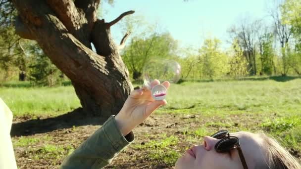 Une Femme Souffle Des Bulles Couchées Sur Une Prairie Verte — Video