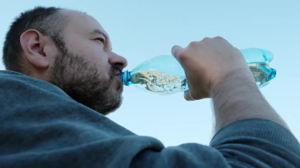 不刮胡子的人喝室外塑料瓶里的水 口渴难忍 — 图库视频影像