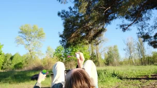 Una Donna Soffia Bolle Sdraiata Prato Verde Nel Parco Rilassante — Video Stock