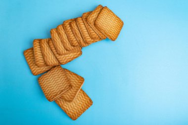 Mavi arka planda karamelli kurabiyeler. Tatlı tatlı.