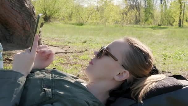 Женщина Лежит Траве Парке Телефоном Руке — стоковое видео