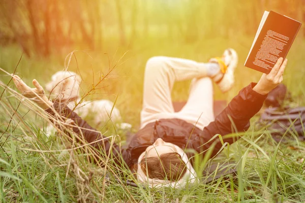 Una Mujer Está Leyendo Libro Tendido Hierba Bosque Bajo Sol —  Fotos de Stock