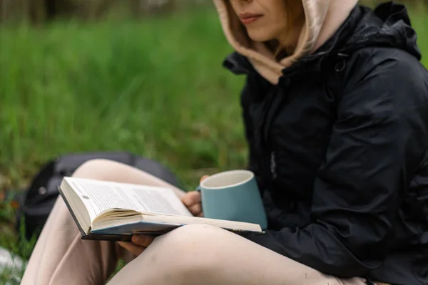 Una Mujer Con Una Taza Libro Parque Sienta Hierba Verde —  Fotos de Stock