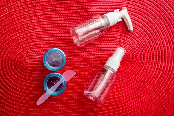 一套塑料容器 用于红色背景的航空旅行的容器 — 图库照片