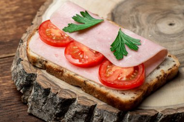 Ahşap arka planda jambonlu ve domatesli tost..