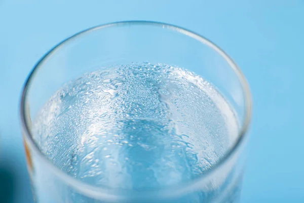 青い背景に純粋な冷たい水のガラスを閉じるウェット — ストック写真