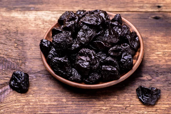 Dried prunes on a wooden background. Dry fruits.