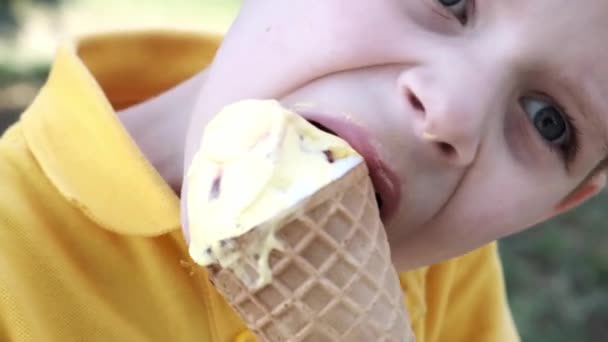 若い男の子が路上で夏にアイスクリームを食べます — ストック動画