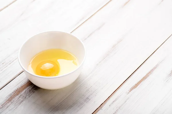 Œuf Cru Dans Une Assiette Sur Fond Bois Blanc — Photo