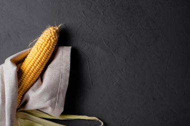 Gri bir zeminde soyulmuş çiğ mısır..