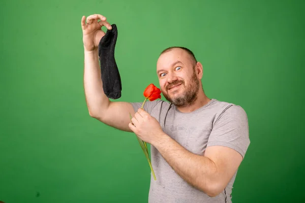 Мужчина Средних Лет Держит Грязный Вонючий Носок Свежий Цветок Зеленом — стоковое фото