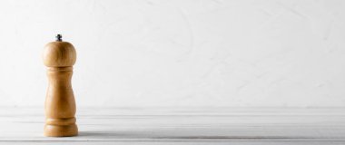 Beyaz ahşap arka planda ahşap biber öğütücü. Mutfak afişi. Metin eklenecek yer.