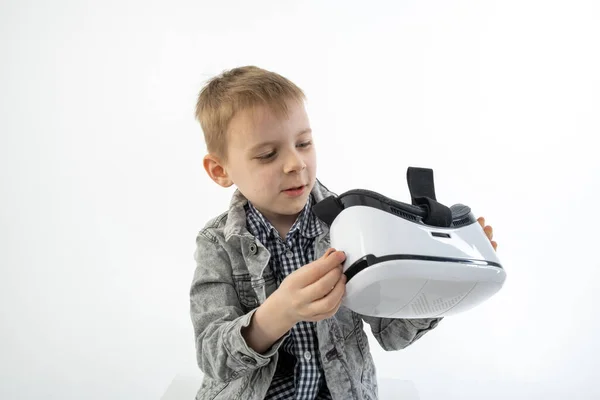 一个戴着白色背景的虚拟现实眼镜的小男孩 孩子们玩 玩3D眼镜很开心 — 图库照片