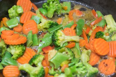 Tavada farklı sebze karışımından sebze güveci pişirmek..