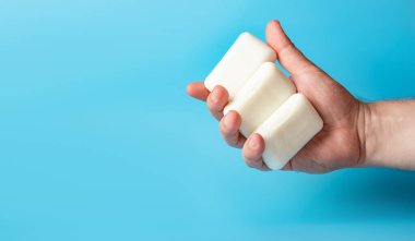 Küresel Bulaşık Günü. Beyaz arka planda bir adamın elindeki sabun kalıpları. Kişisel temizlik konsepti, el yıkama. Pankart, metin için yer.