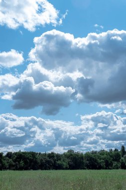Açık güneşli havada mavi gökyüzünde koyu beyaz bulutlar.