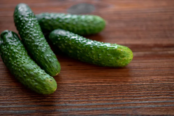 Verse Komkommers Een Donkere Houten Ondergrond — Stockfoto