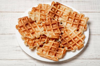 Beyaz tabakta süzme peynirden yapılmış Belçika ev yapımı waffle 'lar..