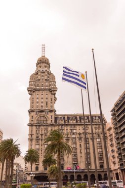 Montevideo, Uruguay, Eylül, 25, 2016: Palacio Salvo ve Uruguay bayrağı, Uruguay 'ın başkenti Montevido' nun bağımsızlık meydanında, ülkenin ve şehrin iki simgesi veya simgesi.