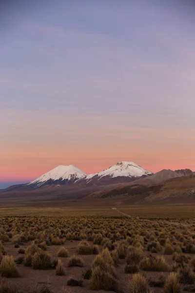 Zachód słońca w Andach. Wulkany Parinacota i Pomerade. — Zdjęcie stockowe