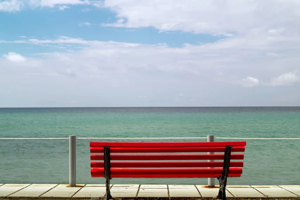 Liten röd bänk med utsikt över Egeiska havet — Stockfoto