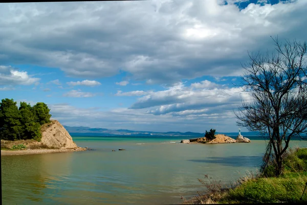 Güneşli bir günde güzel bulutlar ile küçük deniz feneri — Stok fotoğraf