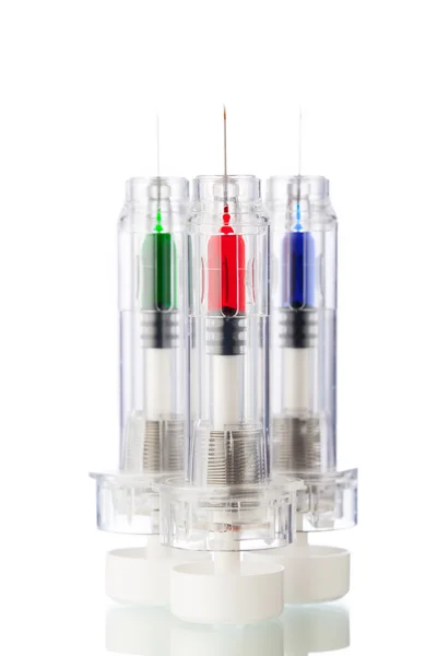 Jeringas desechables con vacunas multicolores, aisladas en blanco — Foto de Stock