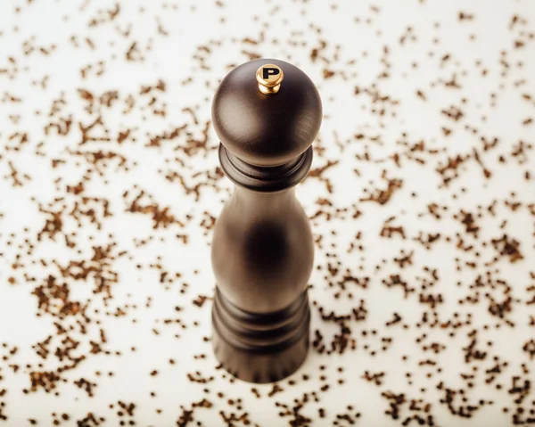 Pepper mill and peppercorns, white background — Stock Photo, Image