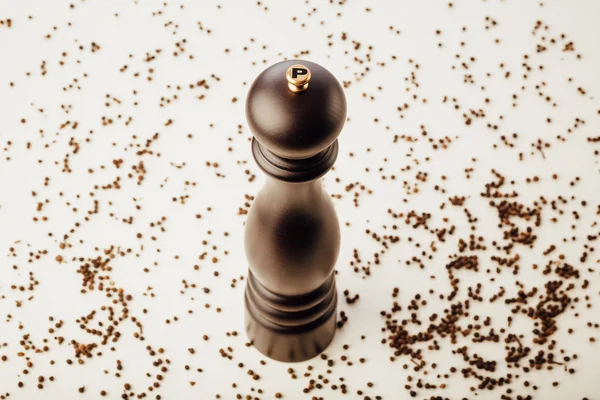 Pepper mill and peppercorns, white background — Stock Photo, Image