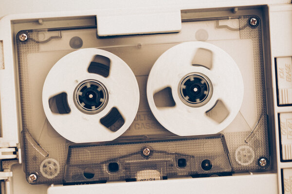 rewinding of vintage audio tape compact cassette, sepia tone with artistic film noise