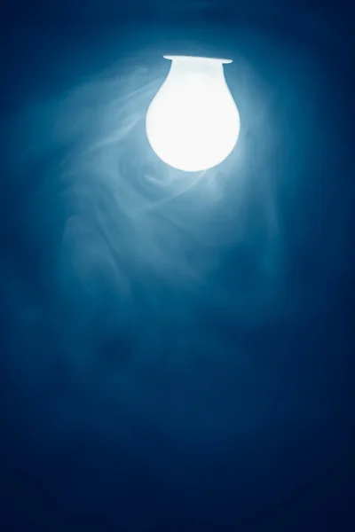 Bulb lamp blue light in fog — Stock Photo, Image