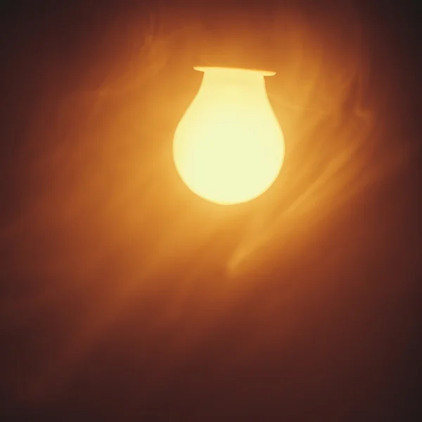 Lampe ampoule lumière chaude dans le brouillard — Photo