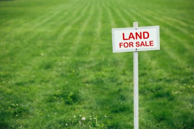 land for sale sign against trimmed lawn background clipart