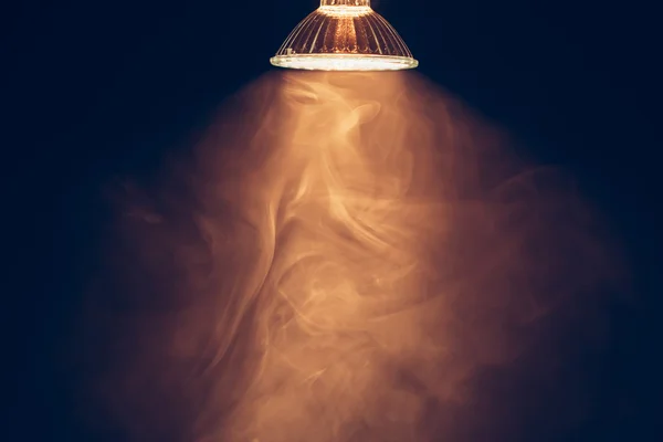 Halogenová lampa s odrážečem, teplé světlo v kouři — Stock fotografie