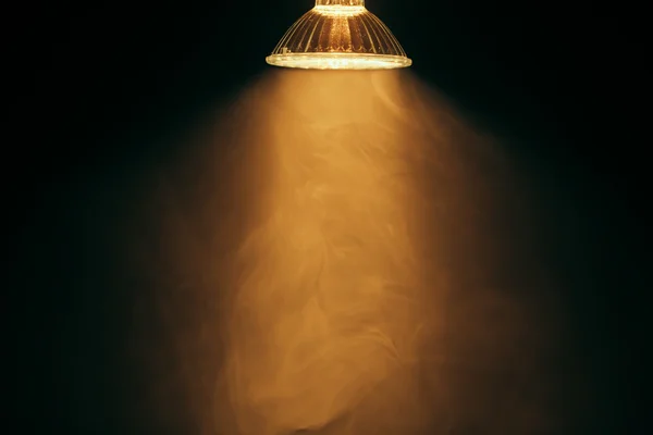 Halogen lamp with reflector, warm light in fog — Stock Photo, Image