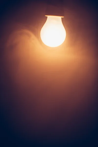 Lampe ampoule lumière chaude dans le brouillard — Photo