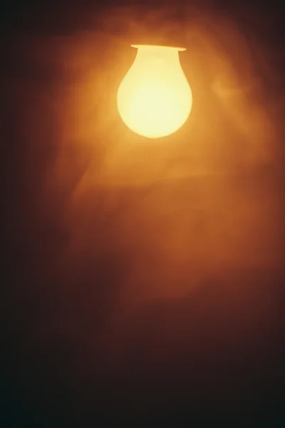 Lámpara de bombilla luz caliente en la niebla — Foto de Stock