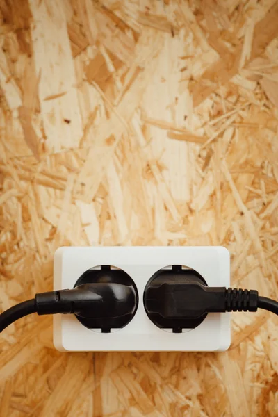 AC power plug and socket, wooden osb wall background — Stock Photo, Image