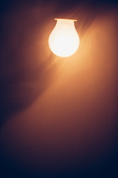 Lámpara de bombilla luz caliente en la niebla — Foto de Stock