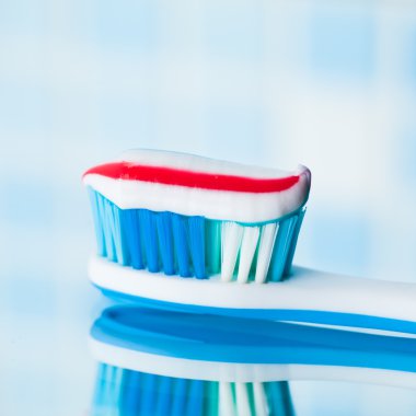 kırmızı çizgili diş macunu ile mavi diş fırçası