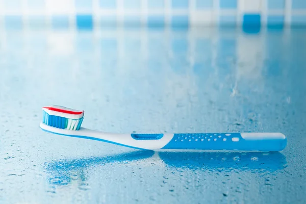 Escova de dentes com pasta de dentes listrada vermelha — Fotografia de Stock