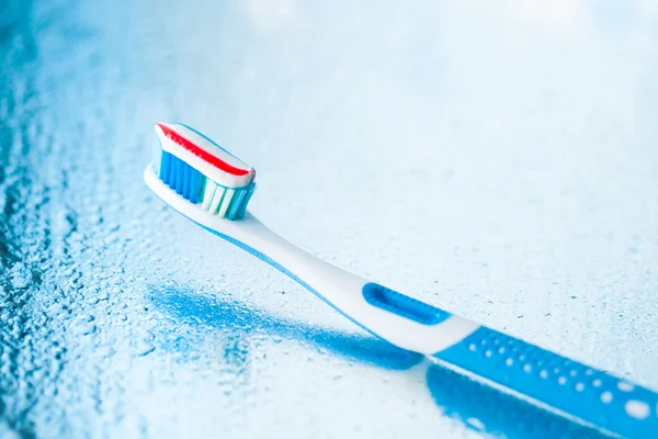 Kırmızı çizgili diş macunu ile diş fırçası — Stok fotoğraf