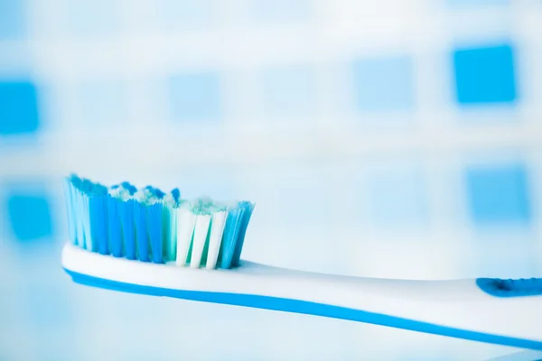 Toothbrush on blue tile background — Stock Photo, Image