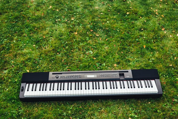 电钢琴上绿草背景 — 图库照片