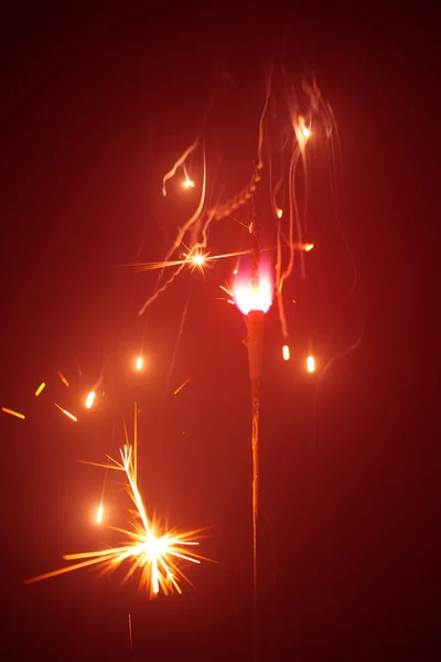 Christmas sparkler in haze with red light — Stock Photo, Image