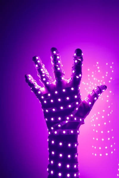 human hand covered with purple led lights, illuminated background