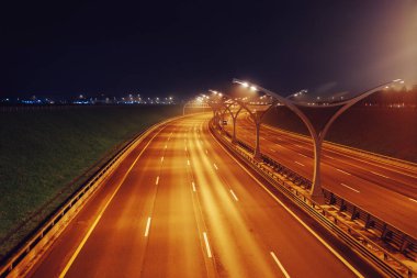 Gece şehir otoyolu sokak lambalarıyla aydınlanıyor.