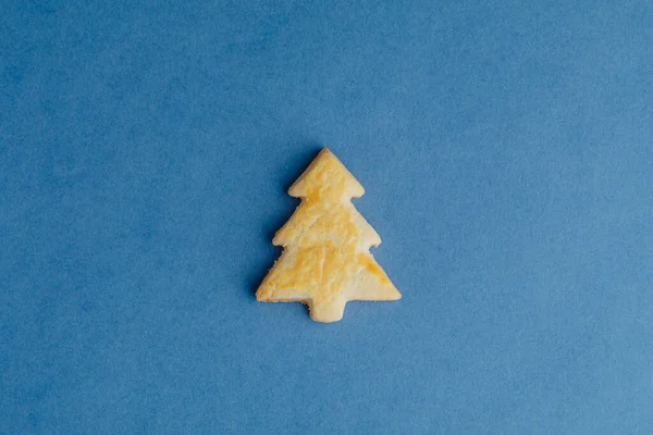 青い紙の背景にクリスマスツリークッキー — ストック写真